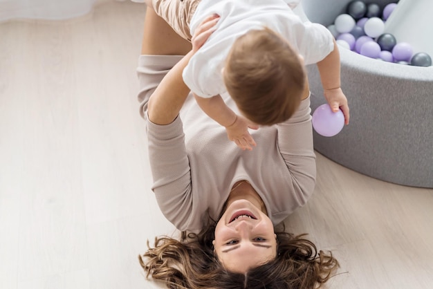 Criança feliz com a mãe brincar no quarto