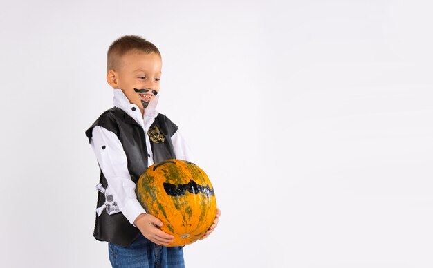 Criança feliz com arte facial. Garoto recolhendo abóbora amarela de halloween. Atividades de outono para crianças.