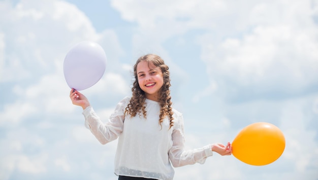 Criança feliz com balões de ar coloridos sobre o fundo do céu azul expressam emoções positivas apenas se divertem liberdade férias de verão celebração dia internacional das crianças Ideia engraçada