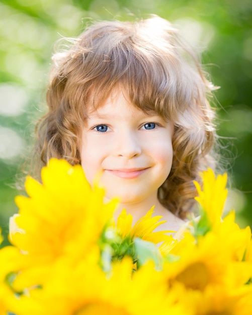 Criança feliz com buquê de lindos girassóis contra fundo verde Conceito de férias em família de primavera Dia das mães