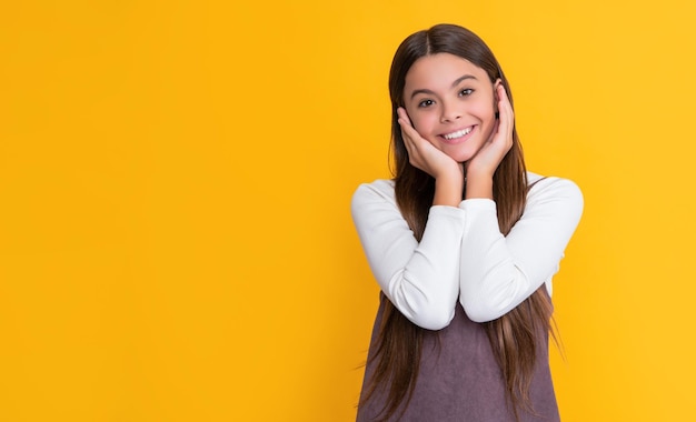 Criança feliz com cabelo comprido em fundo amarelo