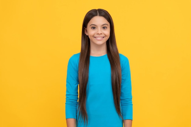 Criança feliz com cabelo comprido na moda de fundo amarelo