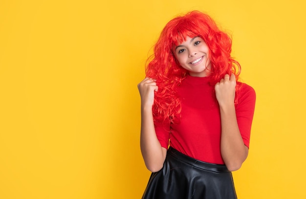 Criança feliz com cabelo comprido vermelho sobre fundo amarelo