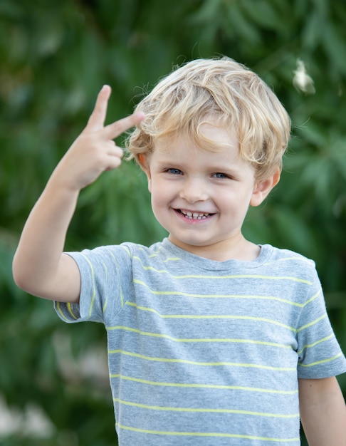 Criança feliz com camiseta azul no jardim