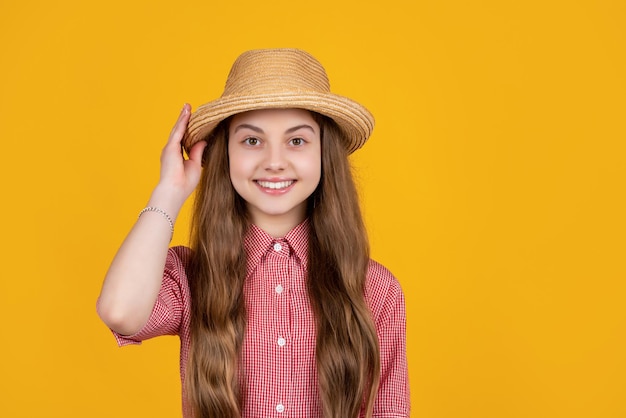 Criança feliz com chapéu de palha em fundo amarelo