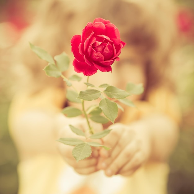 Criança feliz com flores ao ar livre no jardim primavera