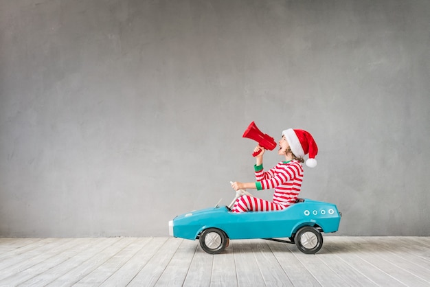 Criança feliz com o presente de Natal. Criança se divertindo em casa