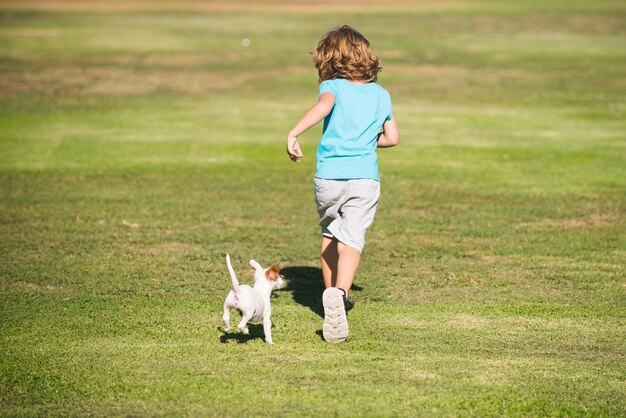 Criança feliz correndo com um cachorro ao ar livre