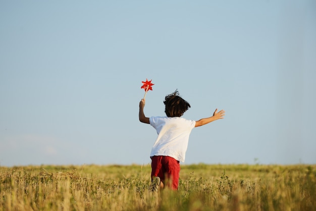 Criança feliz correndo em um belo campo