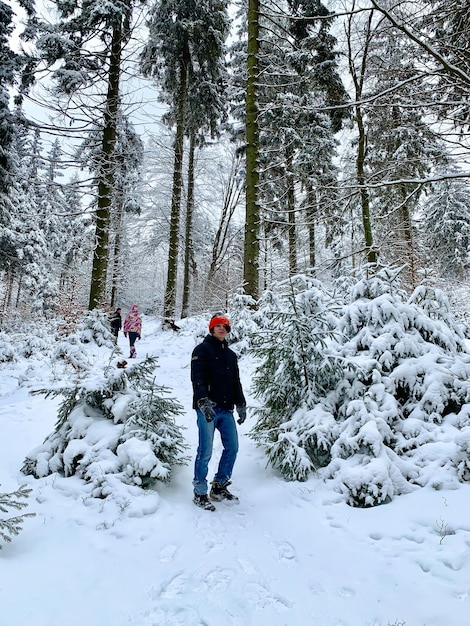 Criança feliz e bela paisagem de inverno Menino adolescente em dia gelado na floresta coberta de neve