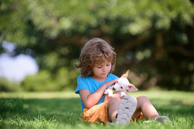 Criança feliz e cachorro de estimação brincando no gramado do quintal