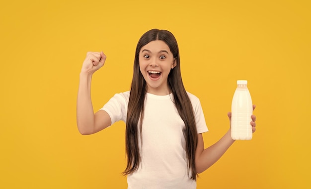 Criança feliz e espantada segura produto de bebida láctea adolescente que vai beber leite