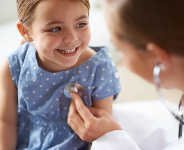 Criança feliz e estetoscópio do pediatra para consulta de saúde verificam os pulmões e a respiração para batimentos cardíacos Criança do médico e avaliação do tórax no hospital clínico e ajudando a paciente menina