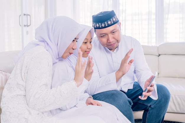 Criança feliz e pais fazem videochamada no Eid