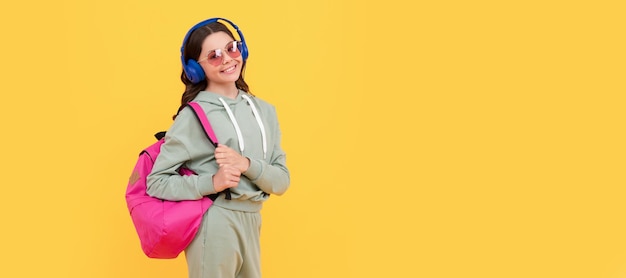 Criança feliz em fones de ouvido carrega mochila de volta ao conhecimento e educação escolar Criança adolescente casual