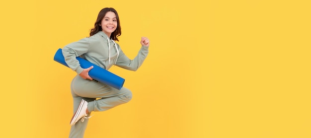 Criança feliz em roupas esportivas correndo com tapete de fitness se encaixa no seu corpo Cartaz horizontal de criança isolada