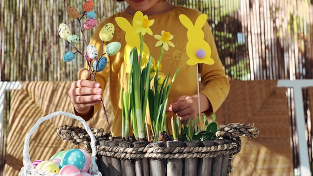 Foto criança feliz fazer composição de páscoa de primavera com flores amarelas papel colorido cesto de ovos de páscua