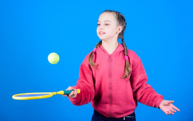 Criança feliz joga tênis no ginásio staduim Sucesso do jogo esportivo Jogador de tênis com raquete e bola Atividade infantil Menina Dieta fitness traz saúde e energia Treino de estádio de ginástica de adolescente