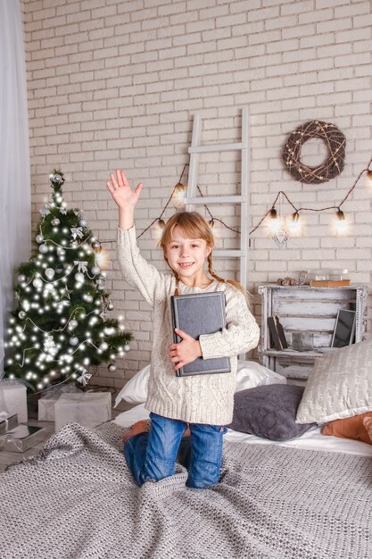 Criança feliz lendo um livro no natal