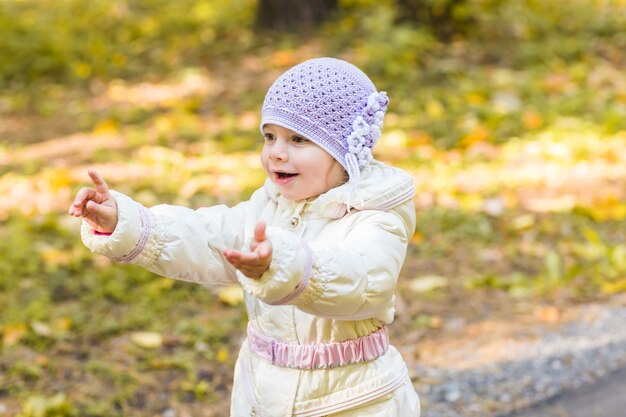 Criança feliz, menina rindo e brincando no outono na natureza caminhada ao ar livre