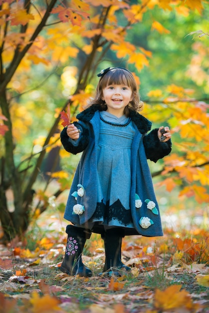 Criança feliz, menina rindo e brincando no outono na natureza caminhada ao ar livre.