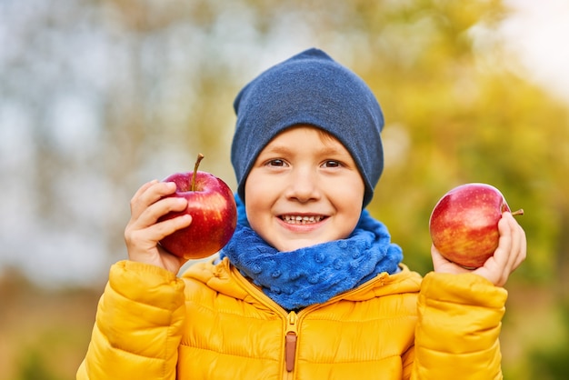 Criança feliz menino brincando lá fora no outono