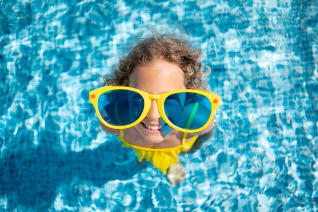 Criança feliz na piscina. Retrato de vista superior