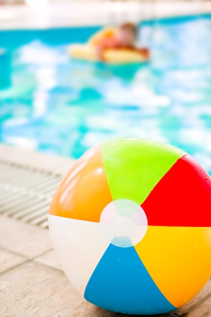 Criança feliz na praia perto da piscina ao ar livre no parque de verão