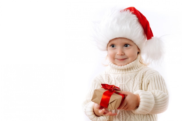 Criança feliz no chapéu de Papai Noel segurar a caixa de presente de Natal