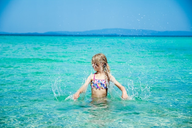 Criança feliz no mar na Grécia brinca na natureza