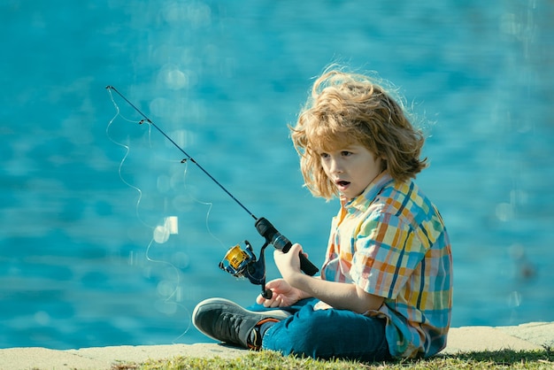 Criança feliz pescando no lago menino com girador no conceito de pesca no rio