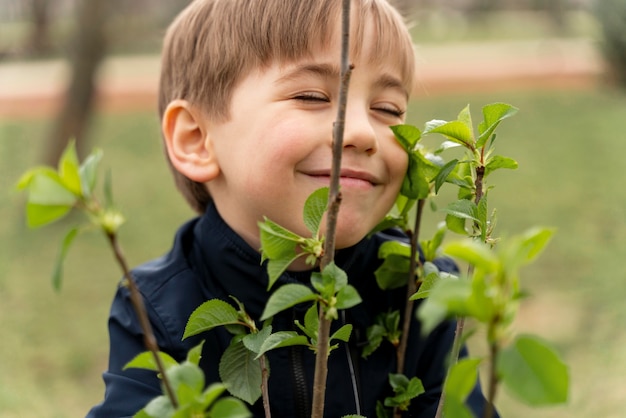 Foto criança feliz por plantar uma árvore