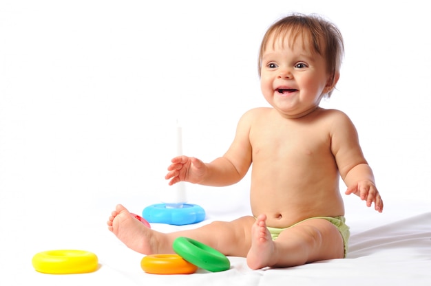 Criança feliz rindo senta e brinca com o brinquedo amado.