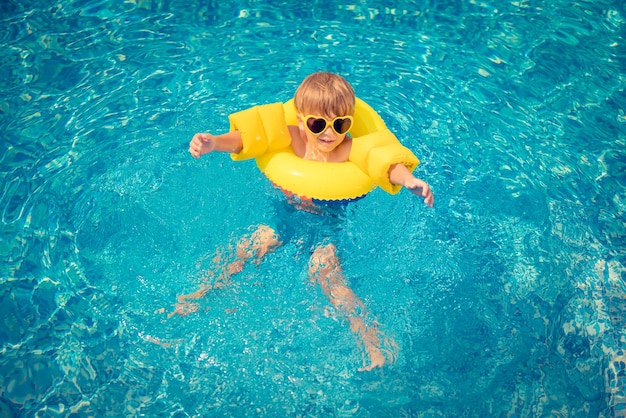 Criança feliz se divertindo nas férias de verão criança brincando na piscina conceito de estilo de vida saudável ativo