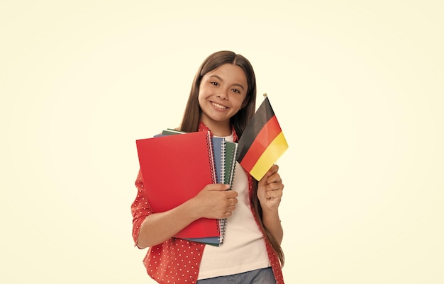 Criança feliz segura bandeira alemã e caderno escolar para estudar isolado em língua estrangeira branca