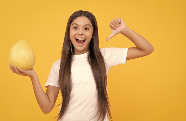 Criança feliz segura grandes frutas cítricas de pumelo amarelo ou pomelo cheio de vitamina saudável para a infância