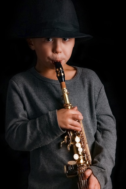 Criança feliz tocando saxofone no estúdio