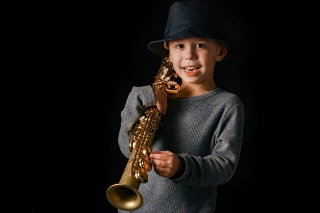 Criança feliz tocando saxofone no estúdio