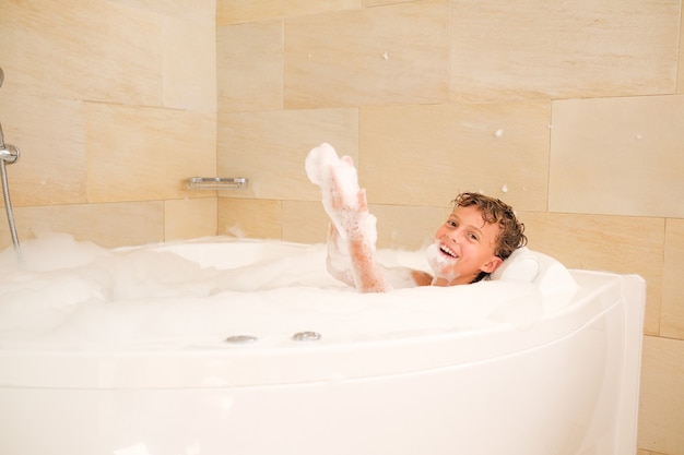 Criança feliz tomando banho de espuma