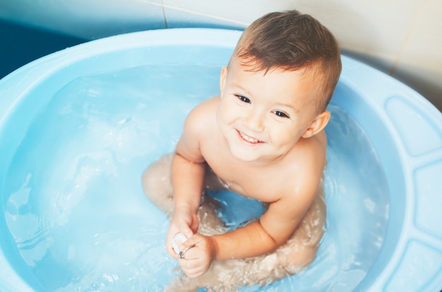 Criança feliz, um menino toma banho muito fofo