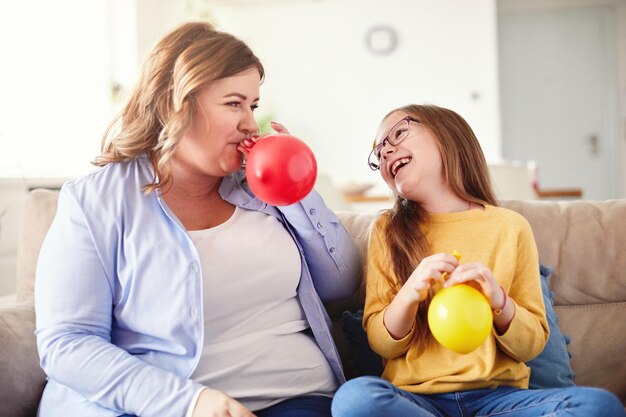 Criança filha balão mãe soprando família feliz brincando criança infância