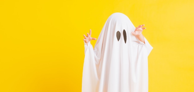 Foto criança fofa com fantasia vestida de branco fantasma de halloween assustador