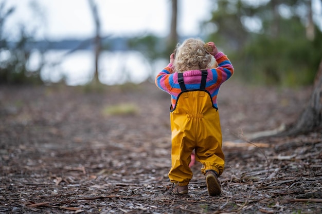 criança fofa na floresta explorando o meio ambiente