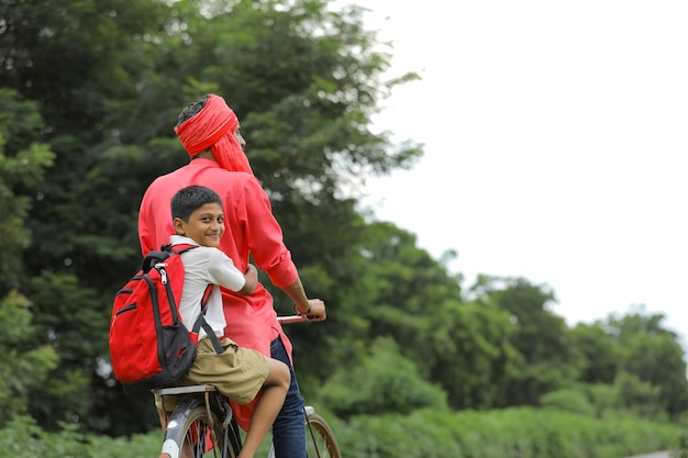 criança indiana brincando com o avião de brinquedo com o pai na bicicleta