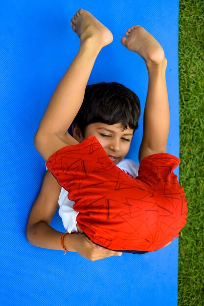 Criança inteligente asiática fazendo yoga pose no parque da sociedade ao ar livre crianças yoga pose o menino