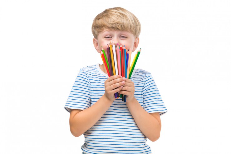 Criança isolada com lápis. Criança adorável em fundo branco. Retrato de menino loiro engraçado com lápis coloridos.