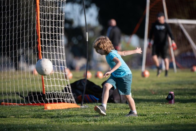 Criança jogando futebol criança feliz desfrutando de esportes jogo de futebol atividades infantis pequeno jogador de futebol