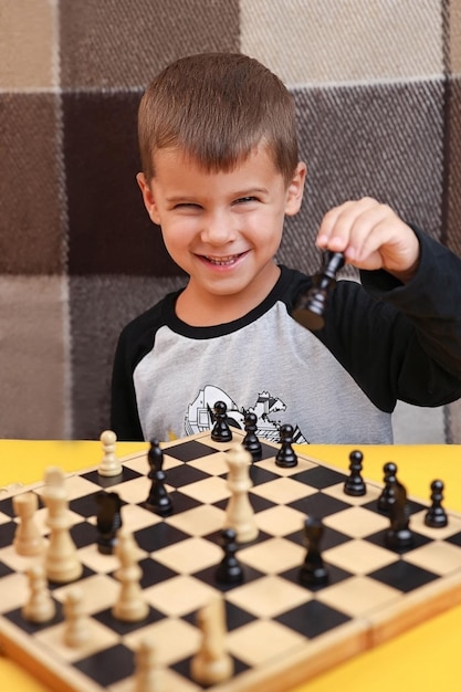 Criança jogando xadrez e sorrindo