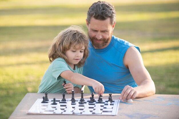 Criança jogando xadrez pai e filho jogando xadrez dia dos pais amor família conceito de infância de paternidade