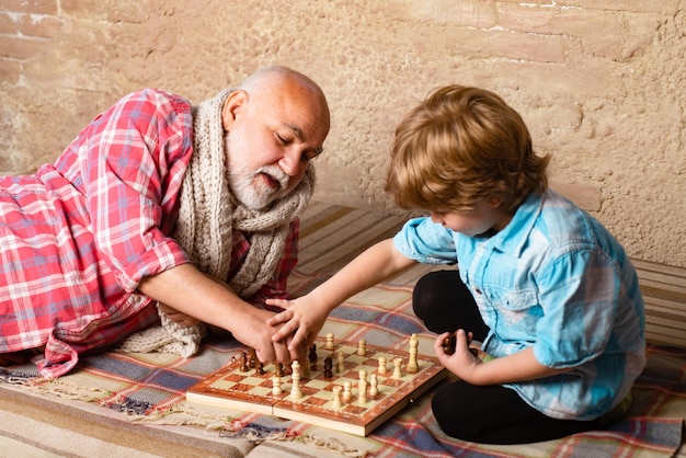 Criança jogando xadrez Peça de xadrez Conceito de avô e neto